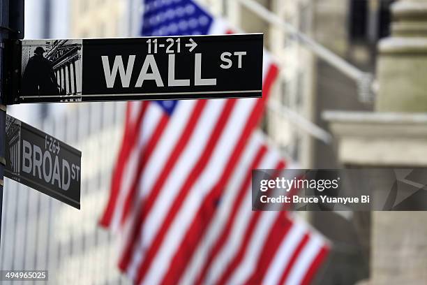 street sign of wall street with american flags - wall street lower manhattan stock pictures, royalty-free photos & images