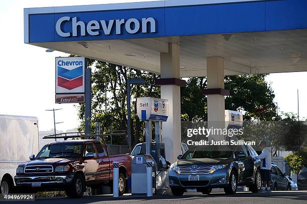 Customers get gasoline at a Chevron station on October 30, 2015 in Corte Madera, California. Chevron announced plans to cut up to 7,000 jobs as oil...