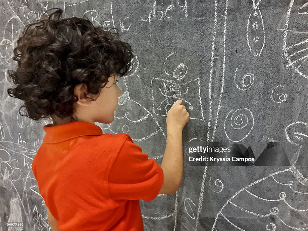 Boy drawing on chalkboard