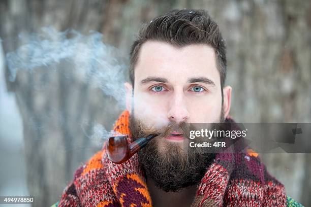 man with beard puffing away at his pipe - amish man stock pictures, royalty-free photos & images