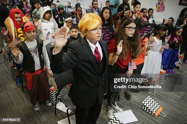 Dressed as Republican presidential candidate Donald Trump, 13-year-old Razvan Godja and 26 other children wear Halloween costumes as they take the...