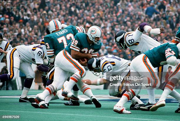 Larry Csonka of the Miami Dolphins carries the ball and gets hit by Roy Winston of the Minnesota Vikings during Super Bowl VIII at Rice Stadium...