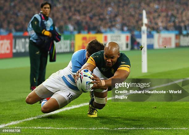 Pietersen of South Africa scores the first try under pressure from Lucas Gonzalez Amorosino of Argentina during the 2015 Rugby World Cup Bronze Final...