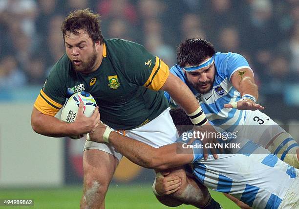 South Africa's prop Frans Malherbe is tackled by Argentina's prop Ramiro Herrera during the bronze medal match of the 2015 Rugby World Cup between...