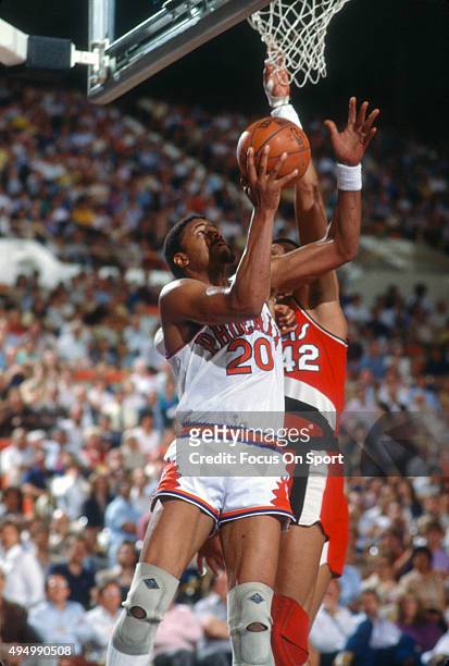 Maurice Lucas of the Phoenix Suns goes up to shoot over Wayne Cooper of the Portland Trail Blazers during an NBA basketball game circa 1984 at the...