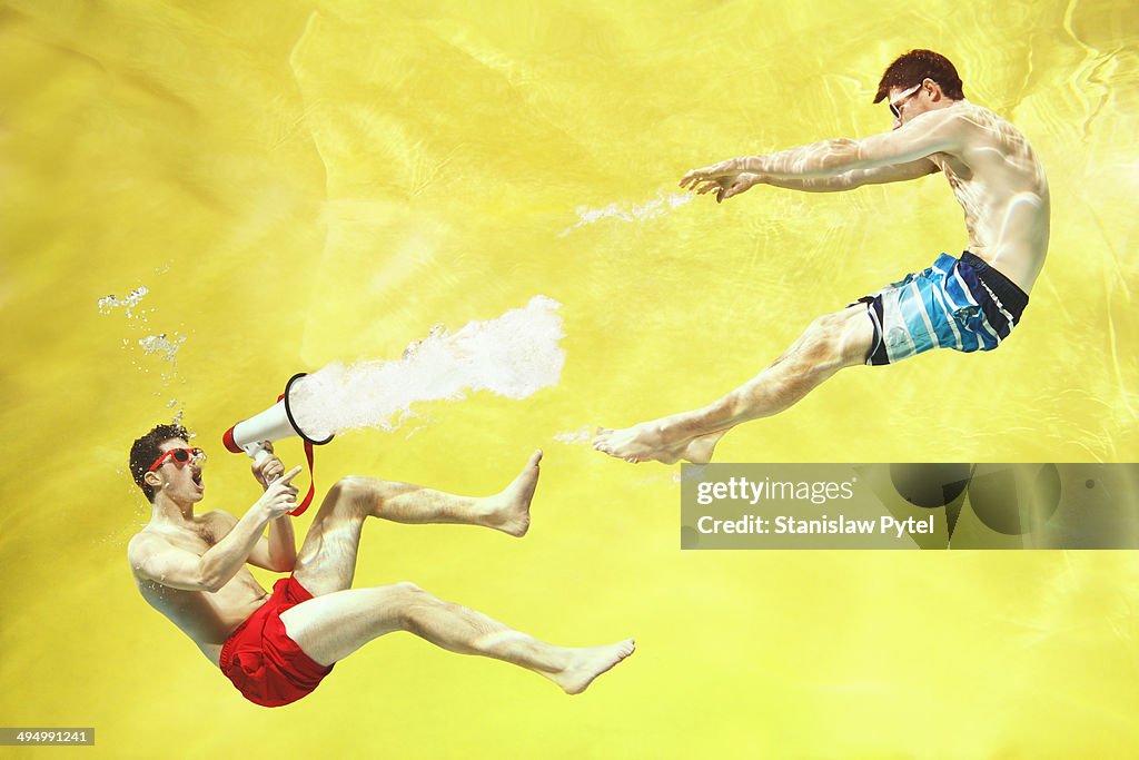 Boy screaming with megaphone on  yellow background