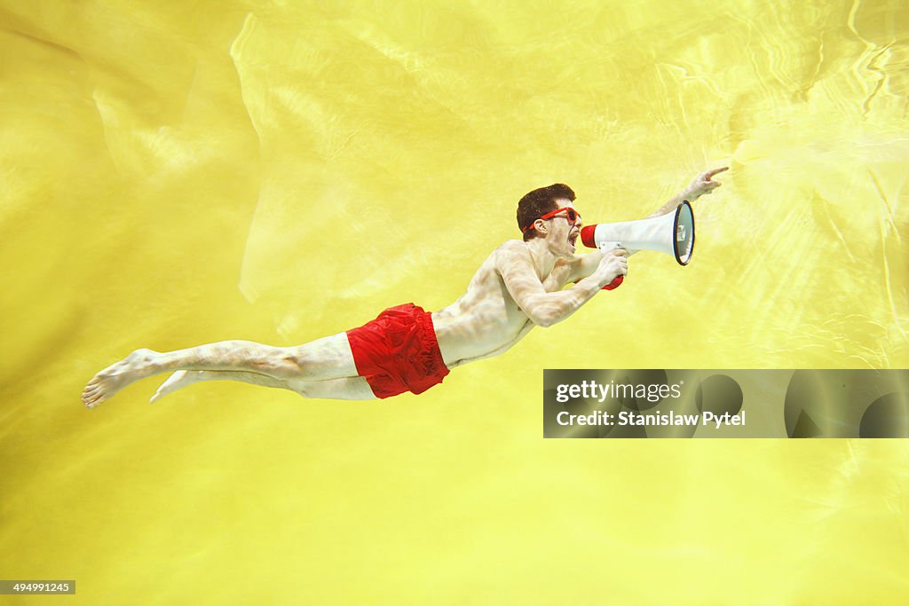 Boy screaming underwater with megaphone