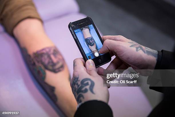 Artist and tattooist Dan Gold uses a mobile phone to photograph his latest tattoo, based on an image of Albert Einstein, in his West Hampstead studio...