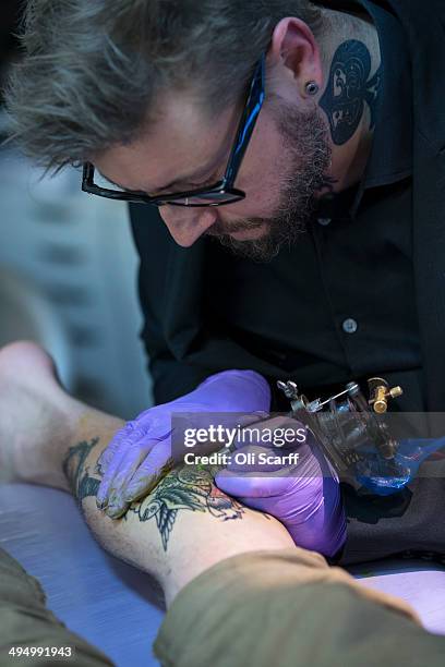 Artist and tattooist Dan Gold creates a tattoo featuring an image of Albert Einstein in his West Hampstead studio on April 22, 2014 in London,...