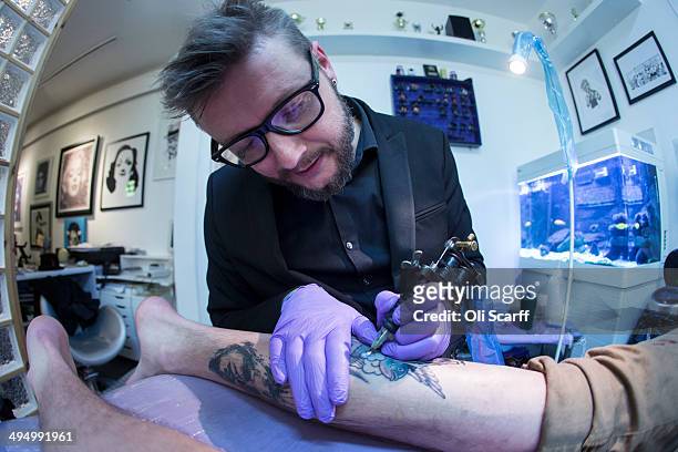 Artist and tattooist Dan Gold creates a tattoo featuring an image of Albert Einstein in his West Hampstead studio on April 22, 2014 in London,...