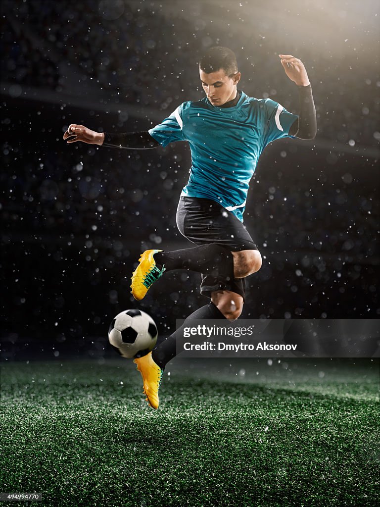 Soccer player kicking ball in stadium