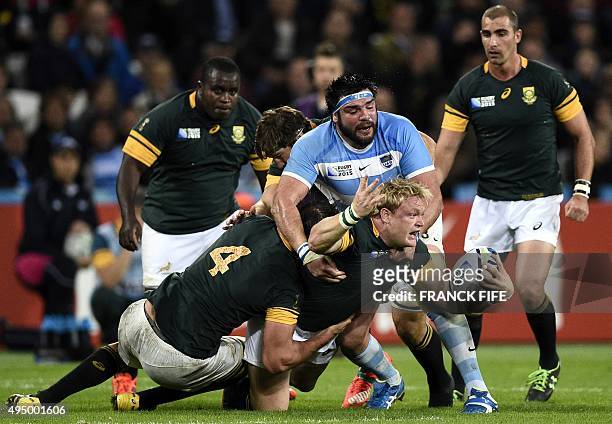 South Africa's hooker Adriaan Strauss is tackled by Argentina's prop Ramiro Herrera during the bronze medal match of the 2015 Rugby World Cup between...