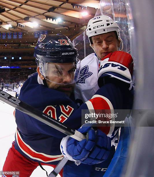 Dan Boyle of the New York Rangers rides Michael Grabner of the Toronto Maple Leafs into the boards during the first period at Madison Square Garden...