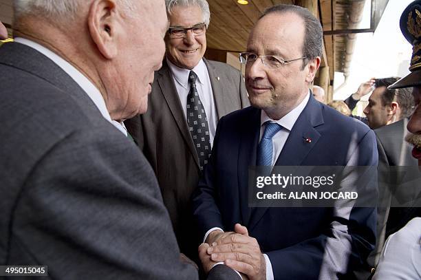 French President Francois Hollande shakes hands with a WWII veteran on June 1 in Asnelles during a visit ahead of commemorations marking the 70th...