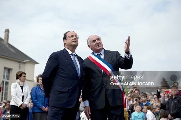 French President Francois Hollande speaks with Trevieres' mayor Jean-Pierre Richard during a ceremony to honor WWII civilian casualties in Trevieres,...