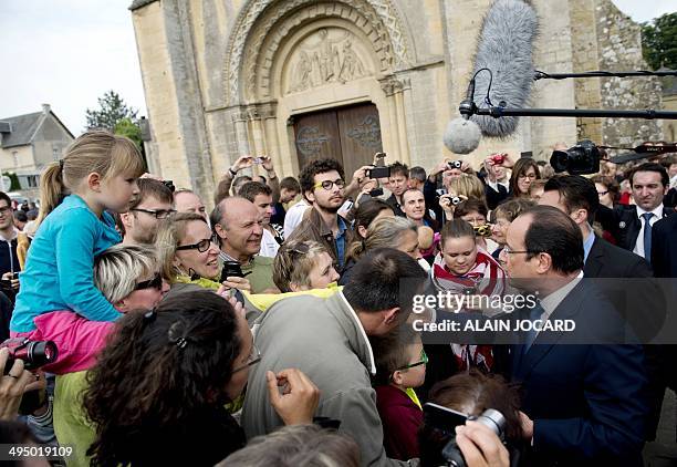 French President Francois Hollande shakes hands with people during a ceremony to honor WWII civilian casualties in Trevieres, on June 1 as part of a...