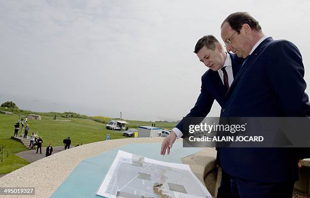 French President Francois Hollande looks at a document as he tours the area around Gold Beach, one of the five designated beaches that were used...