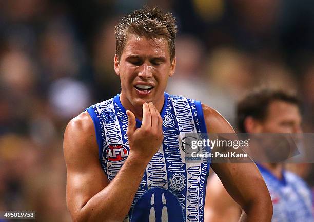 Andrew Swallow of the Kangaroos holds his jaw after coming from the field during the round 11 AFL match between the West Coast Eagles and the North...