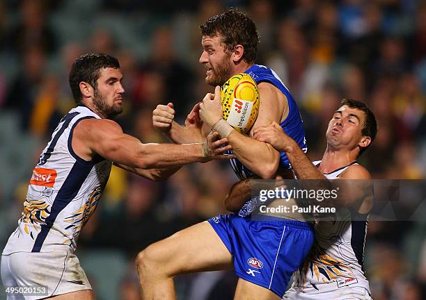 Lachlan Hansen of the Kangaroos marks the ball against Jack Darling and Jamie Cripps of the Eagles during the round 11 AFL match between the West...