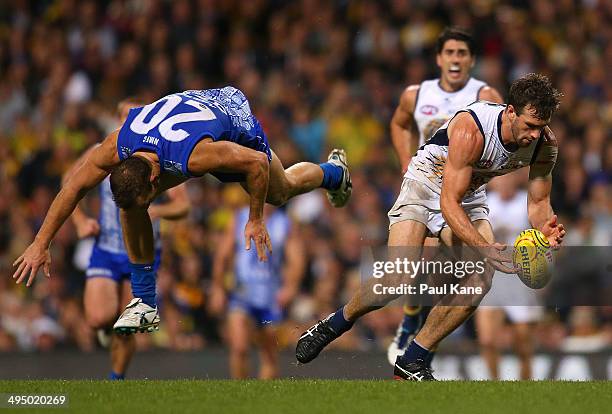 Eric Mackenzie of the Eagles gathers the ball against Drew Petrie of the Kangaroos during the round 11 AFL match between the West Coast Eagles and...