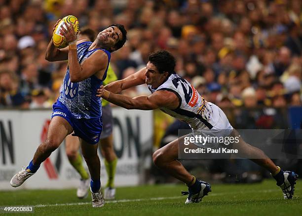 Lindsay Thomas of the Kangaroos avoids a tackle by Matt Rosa of the Eagles during the round 11 AFL match between the West Coast Eagles and the North...