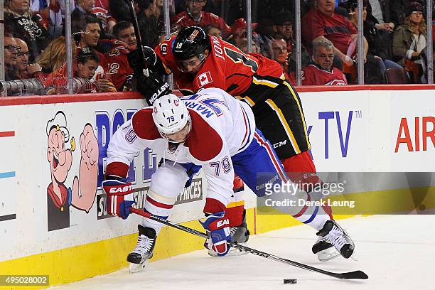 David Jones of the Calgary Flames checks Andrei Markov of the Montreal Canadiens during an NHL game at Scotiabank Saddledome on October 30, 2015 in...