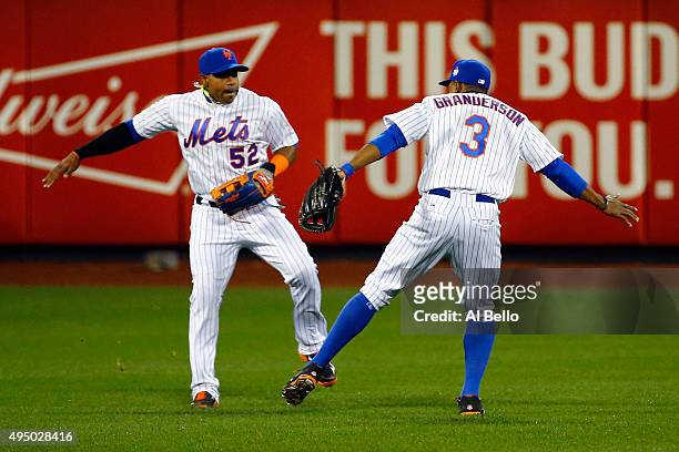 Yoenis Cespedes and Curtis Granderson of the New York Mets celebrate after defeating the Kansas City Royals by a score of 9-3 to win Game Three of...