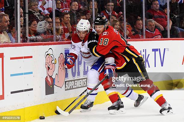 Matt Stajan of the Calgary Flames checks Brian Flynn of the Montreal Canadiens during an NHL game at Scotiabank Saddledome on October 30, 2015 in...