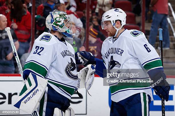 Goaltender Richard Bachman of the Vancouver Canucks is congratulated by Yannick Weber after defeating the Arizona Coyotes 4-3 in the NHL game at Gila...