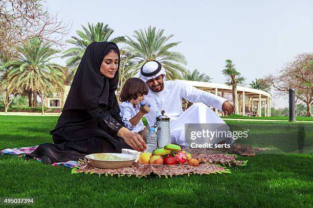 middle eastern family enjoying picnic outdoors - dubai palm stock pictures, royalty-free photos & images