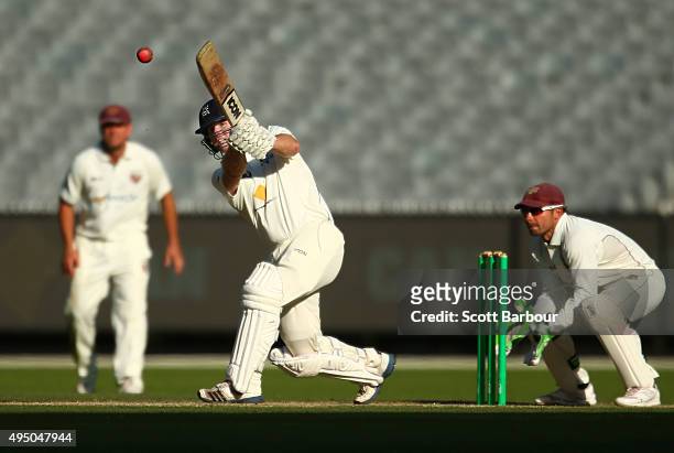 Travis Dean of Victoria bats as wicketkeeper Chris Hartley of Queensland looks on during day four of the Sheffield Shield match between Victoria and...