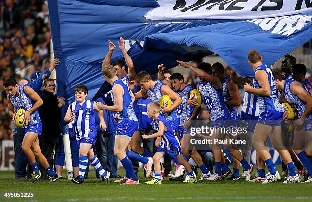 The Kangaroos run thru their banner during the round 11 AFL match between the West Coast Eagles and the North Melbourne Kangaroos at Patersons...