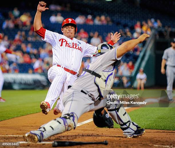 May 27: Carlos Ruiz of the Philadelphia Phillies is forced out at home plate by Wilin Rosario the Colorado Rockies during the third inning at...