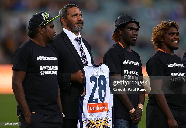 Former Eagles player Chris Lewis looks on with Western Desert sports council representatives before the round 11 AFL match between the West Coast...