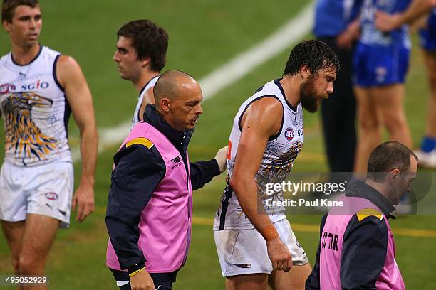 Josh Kennedy of the Eagles is assisted to the bench after receiving a heavy knock in a marking contest during the round 11 AFL match between the West...