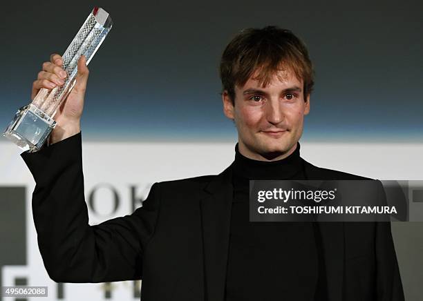 Slovenia's film director Olmo Omerzu poses with his Best Artistic Contribution Award trophy during the closing ceremony of the 28th Tokyo...