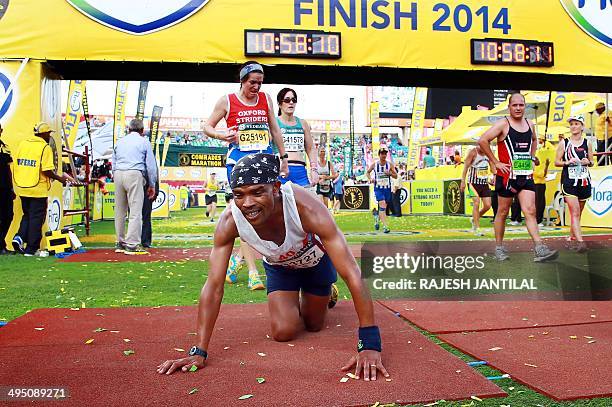 An exhausted Comrades Marathon runner collapses as he arrives at the finishing line at the end of the 89km Comrades Marathon between Pietermaritzburg...