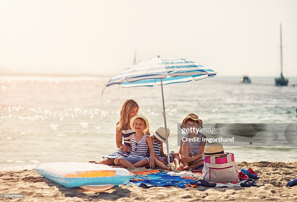 Kids and mother enjoying summer vacation on the beach