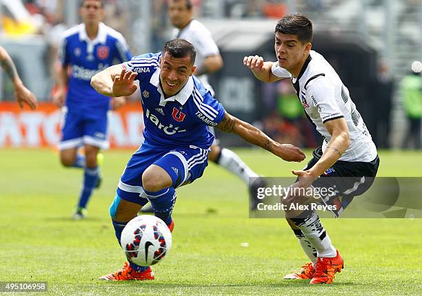 Sebastian Ubilla of U de Chile fights for the ball with Cristian Gutierrez of Colo Colo during a match between Colo Colo and U de Chile as part of...