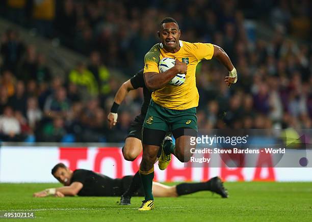 Tevita Kuridrani of Australia breaks clear to score his try as Dan Carter of the New Zealand All Blacks looks on from the floor during the 2015 Rugby...