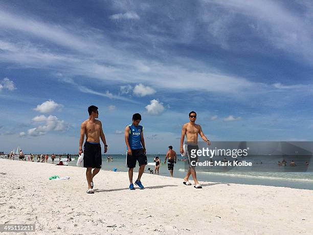 Eiji Kawashima, Atsuto Uchida and Maya Yoshida of Japan walk along Clearwater beach on June 1, 2014 in Clearwater, Florida.