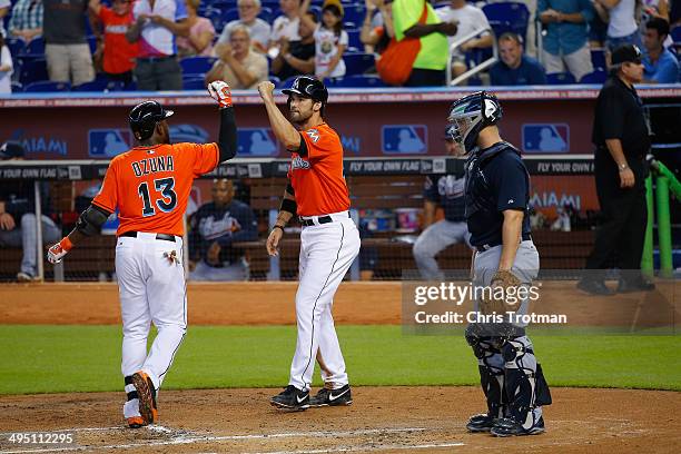 Marcell Ozuna of the Miami Marlins celebrates a two run homer in the second inning to score teammate Garrett Jones of the Miami Marlins as Evan...