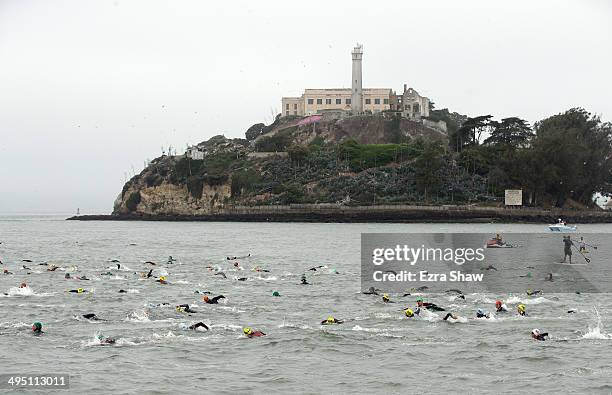 Competitors swim past Alcatraz at the start of the 2014 Escape from Alcatraz Triathlon on June 1, 2014 in San Francisco, California.