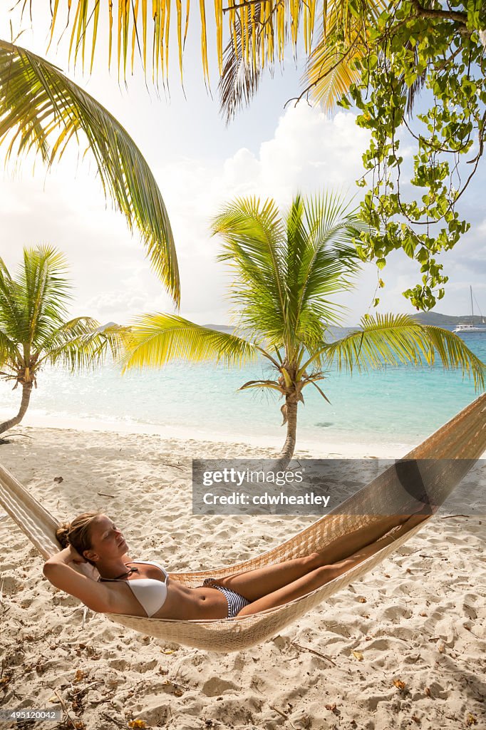Woman relaxing in hammock at Salomon Bay Beach, St.John, USVI