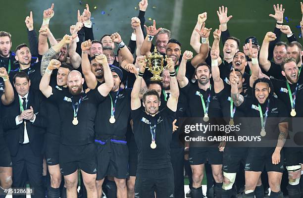 New Zealand's flanker and captain Richie McCaw holds the Webb Ellis Cup as he celebrates with teammates after winning the final match of the 2015...