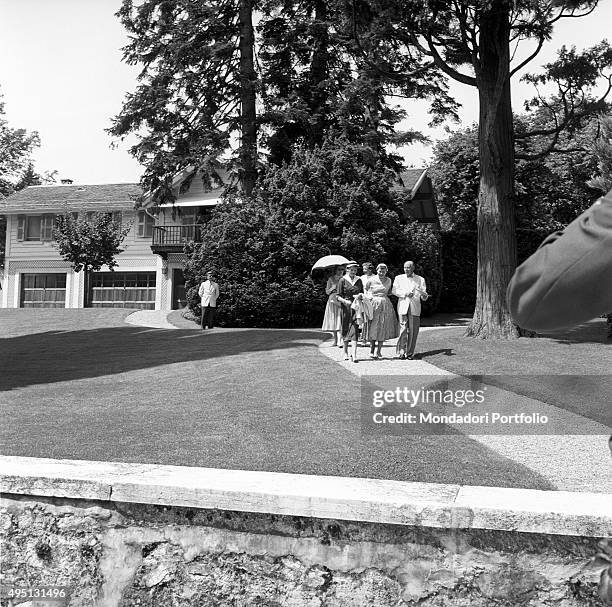 Four women and an elderly man walking in the garden of a mansion during the Geneva Summit to discuss global security, German unification and...