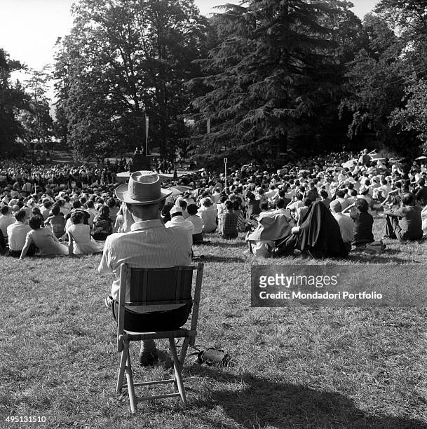 Crowd of people sitting on the meadow of a park during the Geneva Summit to discuss global security, German unification and disarmament. Geneva, 18th...