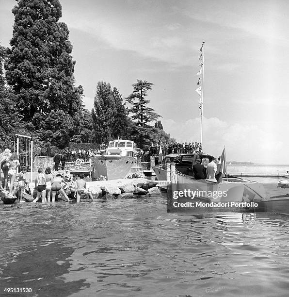 On the shore of Lake Geneva some bathers watching the delegations approaching the pier on board a boat during the proceedings of the Geneva Summit to...