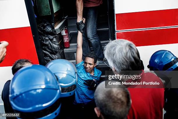 Policemen pushing into a bus a migrant protesting against the evacuation. African migrants have created makeshift shelters in Ventimiglia, the last...