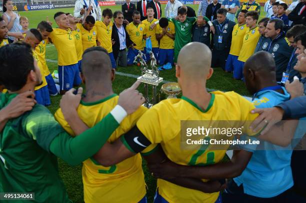 Brazil players and coaches get together and seem to pray as they celebrate their victory with the trophy during the Final of the Toulon Tournament...